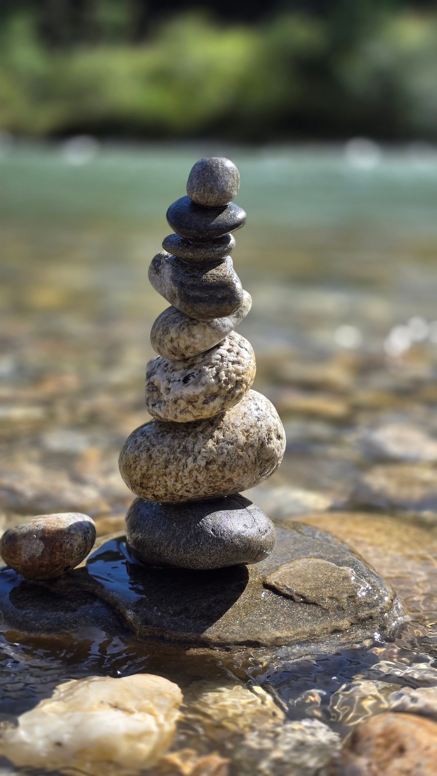 Tranquil stone stack at a riverside in Bhutan, capturing nature's harmony and balance.